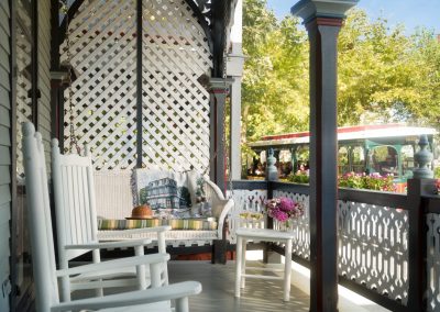 Lord Melbourne's Private Porch with Porch Swing, Rocking Chairs, and a Trolley Passing by in the Background.